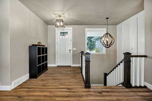 Entryway featuring a chandelier and dark wood-style flooring