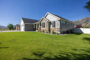 View of front of property featuring stone siding, a mountain view, covered porch, board and batten siding, and driveway