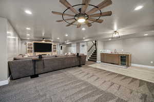 Living room featuring wet bar, recessed lighting, beverage cooler, light carpet, and stairs