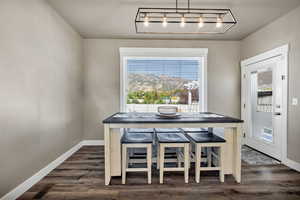 Dining area featuring baseboards and dark wood-style flooring