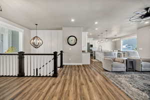Living room featuring dark wood-type flooring, a chandelier, recessed lighting, and ceiling fan