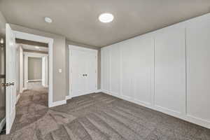 Unfurnished bedroom with dark carpet and a closet