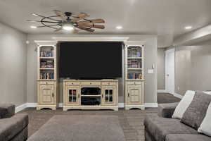 Carpeted living room featuring ceiling fan and recessed lighting