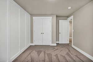 Unfurnished bedroom featuring carpet floors and a closet