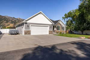 Craftsman-style home with stone siding, concrete driveway, and a garage