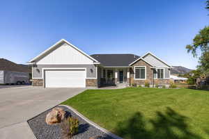 Craftsman inspired home featuring stone siding, a porch, concrete driveway, a garage, and a mountain view