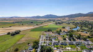 Aerial view of sparsely populated area featuring a water and mountain view, farmland, and nearby suburban area