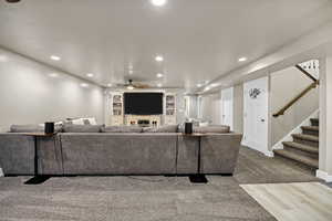 Living room with stairway, recessed lighting, carpet, and ceiling fan