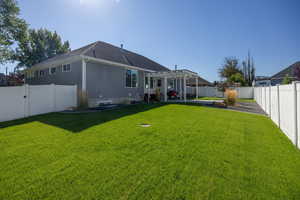 Back of house with a pergola, a fenced backyard, a patio, a gate, and a shingled roof