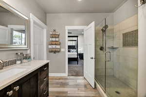 Ensuite bathroom featuring vanity, a stall shower, light wood-style floors, and recessed lighting