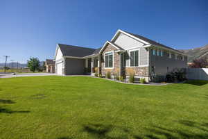 Craftsman house featuring a mountain view, stone siding, concrete driveway, and board and batten siding