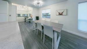 Dining room with dark wood-style flooring and a chandelier