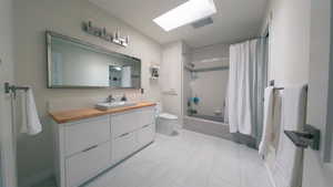 Full bathroom featuring shower / tub combo, vanity, and a skylight