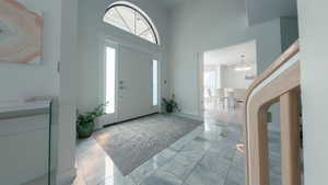 Entryway with marble tile flooring and a high ceiling