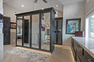 Interior space featuring light wood-style floors, ceiling fan, and high vaulted ceiling