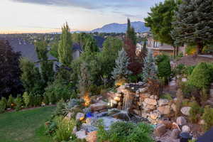 Yard at dusk with a garden pond and a mountain view