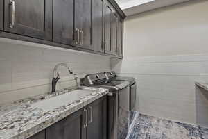 Washroom featuring tile walls, independent washer and dryer, a wainscoted wall, and cabinet space