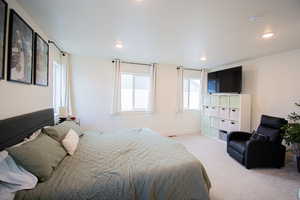 Bedroom with multiple windows, light colored carpet, and recessed lighting
