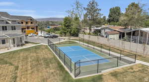 View of tennis court with a residential view and a mountain view