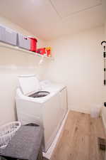 Laundry room featuring light wood finished floors and washing machine and clothes dryer