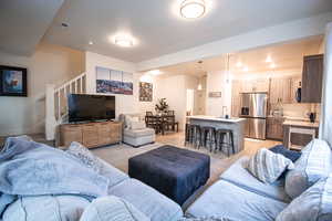 Living area with stairs and light carpet