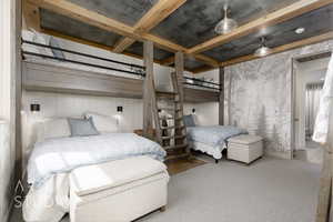 Carpeted bedroom with beam ceiling