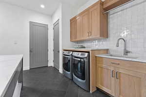 Laundry room with washing machine and dryer, cabinet space, and recessed lighting