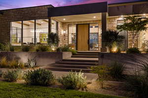 Exterior entry at dusk featuring stone siding