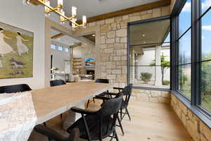 Dining space featuring light wood-style floors, a lit fireplace, and ceiling fan