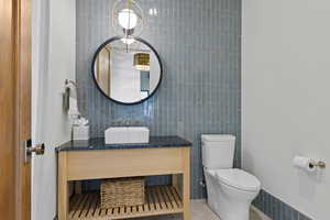 Half bathroom featuring tile walls and vanity