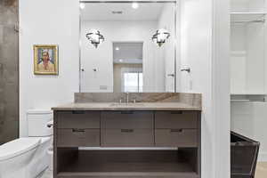 Bathroom featuring vanity, recessed lighting, and a spacious closet