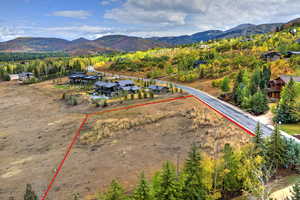 Aerial view of property's location with property parcel outlined and a mountainous background