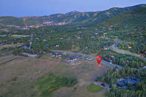 Aerial view of property's location featuring a mountainous background
