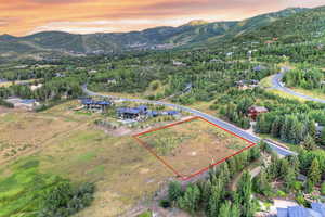 Aerial view at dusk of property parcel outlined and a mountain view