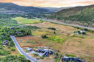 Overview of rural landscape featuring property boundaries highlighted and a mountain backdrop