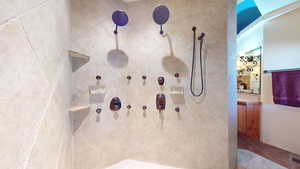 Bathroom view of tiled shower and vanity