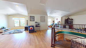 Interior space with lofted ceiling, light wood-style flooring, and recessed lighting