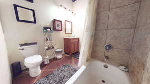 Full bath with vanity, shower / tub combo with curtain, and dark tile patterned floors