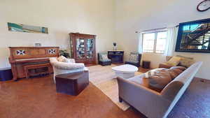Living room with a towering ceiling and tile patterned flooring