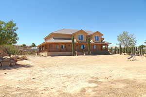 Rear view of property featuring a porch, a tiled roof, and stucco siding