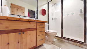 Bathroom featuring a shower stall, vanity, and light tile patterned floors