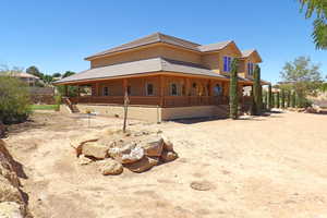 View of side of property featuring covered porch, a tiled roof, and stairway