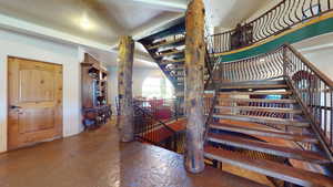 Staircase featuring a textured ceiling and stone tile floors