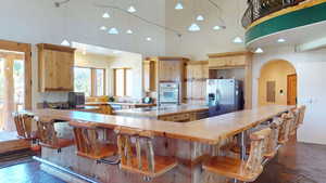 Kitchen featuring light countertops, stainless steel appliances, pendant lighting, a breakfast bar, and recessed lighting