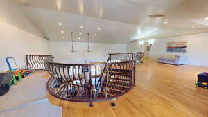 Living area featuring an upstairs landing, lofted ceiling, light wood-style floors, and recessed lighting