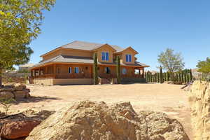 Back of house with covered porch and stucco siding