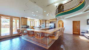 Kitchen with arched walkways, light countertops, light brown cabinetry, stainless steel fridge with ice dispenser, and french doors