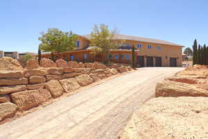 View of front of home with gravel driveway and stucco siding