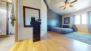 Bedroom with light wood-style flooring, vaulted ceiling, and ceiling fan
