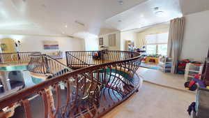 Hallway featuring an upstairs landing, lofted ceiling, carpet, and recessed lighting